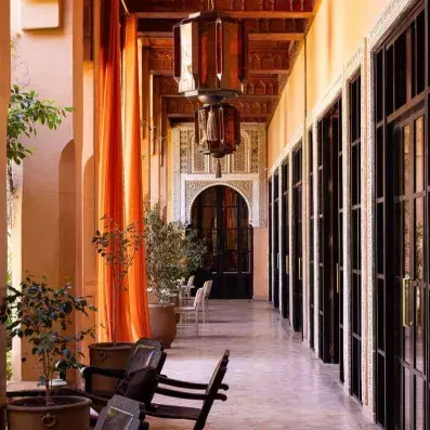 couloir hôtel avec des portes fenêtre a droite et un toit sculpté en bois