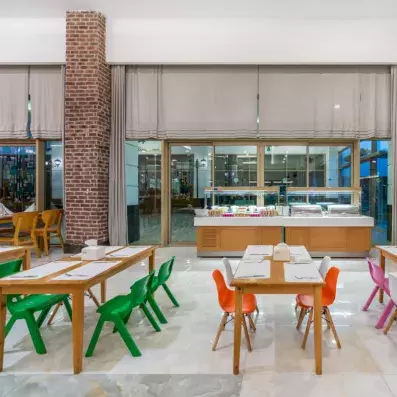 restaurant intérieur avec tables en bois et chaises colorées 