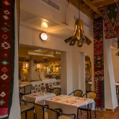 Salon oriental coloré avec service de thé traditionnel et clients profitant d’un moment convivial.