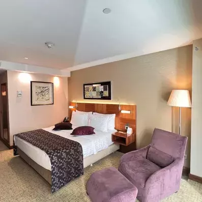 chambre avec un lit double et un fauteuil