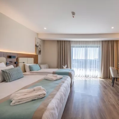 chambre avec un lit double et un lit simple avec une télévision murale