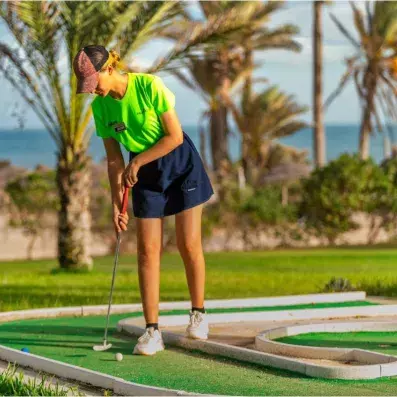 Une femme joue au mini-golf