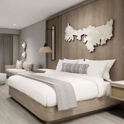 Chambre avec grand lit double et canapé confortables, couleurs claires et épurées