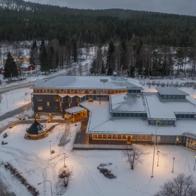 Vue aérienne du complexe hôtelier Matarengi Lodge entouré de forêts enneigées, destination nature et aventure polaire.