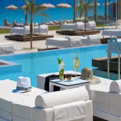 cocktails frais, au bord de la piscine, vue sur plage, transats, palmiers