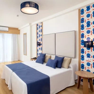 chambre avec deux grand lits simples aux couleurs bleu marine et blanc 