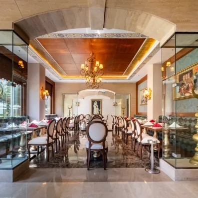 Une grande salle de restaurant spacieuse avec ses tables alignées en rangées.