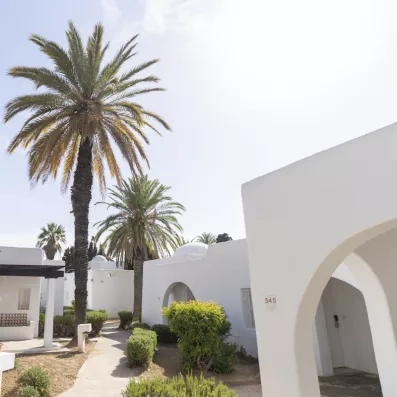 bungalowq blancs sur une allée avec palmiers au mondi club shems all inclusive à monastir