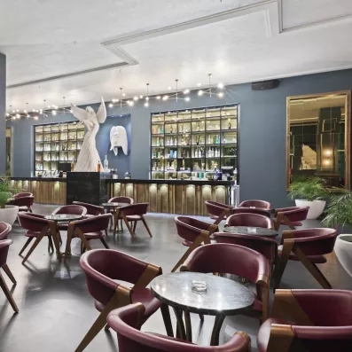 restaurant deco contemporaine statue blanche ailes bar bouteilles mur fauteuils bordeaux