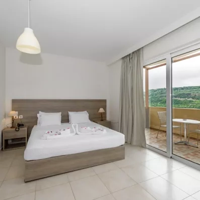 Chambre avec un grand lit double et balcon.