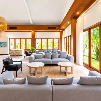 Un salon spacieux et confortable avec des canapés et de grandes baies vitrées ouvrant sur l'extérieur.