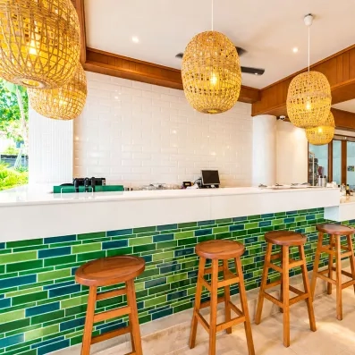 Un bar moderne avec son comptoir orné de carreaux turquoise.