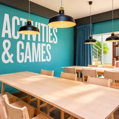 Une salle moderne dédiée aux activités et aux jeux, équipée de grandes tables.