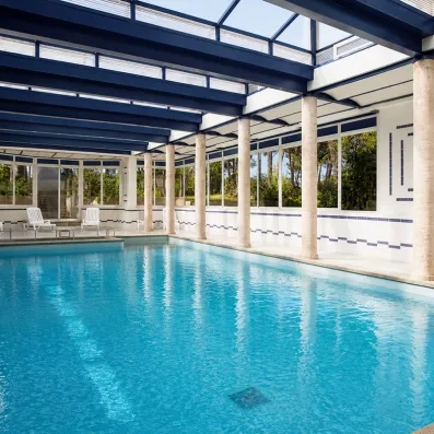 grande piscine intérieure couverte par une pergola