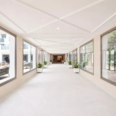long e vague couloir de l'hôtel avec de grandes fenêtres 