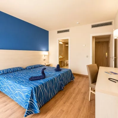 une chambre avec un grand lit double et un bureau