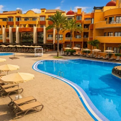 Une piscine extérieure avec vue sur le bâtiment des chambres en arrière plan 