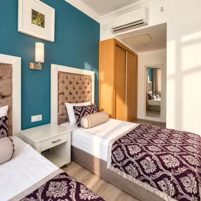 chambre avec deux lits simples et table de chevet