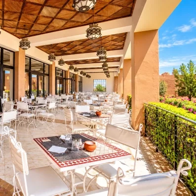restaurant sur la terrasse avec tables en mosaïques et chaises blanches