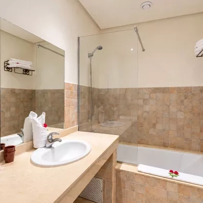 salle de bain avec lavabo intégré et un miroir juste en dessus et une baignoire avec vitre