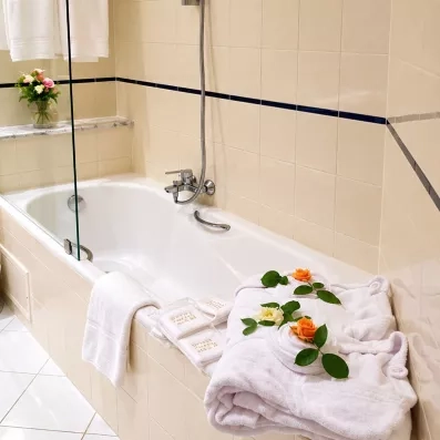 Salle de bain moderne de l'hôtel Nour Palace Mahdia avec baignoire et linge de bain
