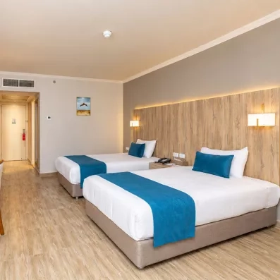 Chambre double moderne du Mondi Club Seven Seas Jolie Bay à Hurghada avec deux lits et tête de lit en bois