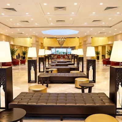 Grand hall d'accueil luxueux du Mondi Club Thalassa Mahdia avec assises en cuir, lampadaires design et architecture lumineuse.