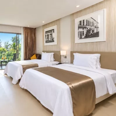 une chambre avec deux lits doubles et des tableaux