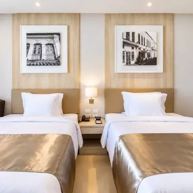 chambre avec deux lits simples et table de chevet au milieu