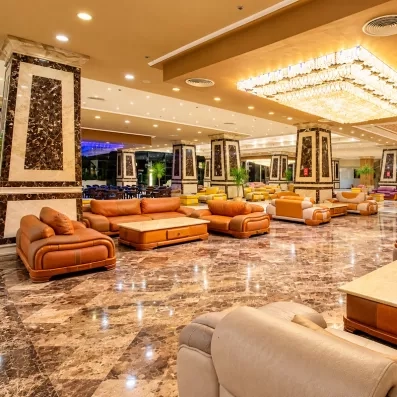 lobby luxueux et élégant avec marbre, lustre fauteuils et canapés marrons au AMC Royal à Hurghada en Egypte