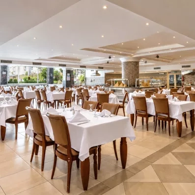 salle du restaurant principale lumineuse avec tables dressées au AMC Royal à Hurghada en Egypte