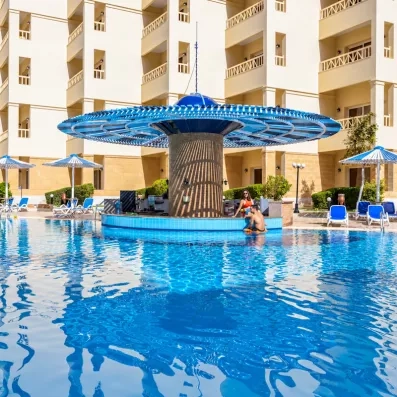 piscine avec décoration centrale, transats et parasols à l'AMC Royal à Hurghada en Egypte