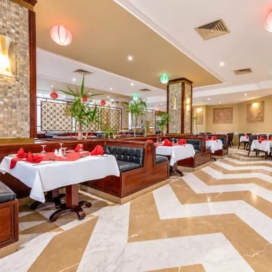 salle de restaurant avec tables dressées et fauteuils au AMC Royal à Hurghada en Egypte
