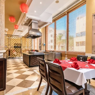 salle de restaurant avec tables dressées et vue sur l'hôtel au AMC Royal à Hurghada en Egypte