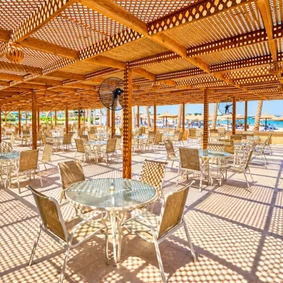 Restaurant d'été à l'ombre d'une pergola en bois au Blend Club Aqua Resort Hurghada avec vue panoramique sur la plage