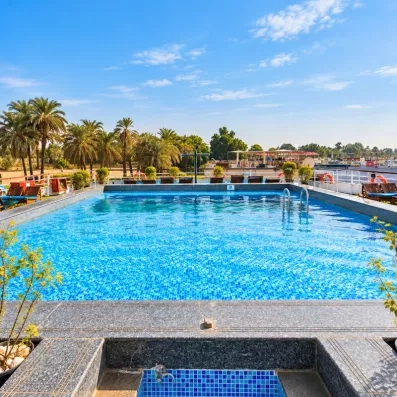 Grande piscine de pont entourée de palmiers, escale farniente durant un circuit touristique en Égypte.