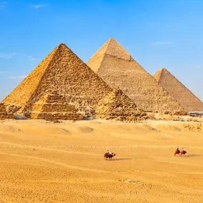 Grandes Pyramides de Gizeh au Caire et caravane de chameaux, merveille du monde et symbole du tourisme.