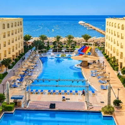 Grande piscine extérieure avec toboggans et parasols à l'hôtel AMC Royal Hotel à Hurghada, Égypte.