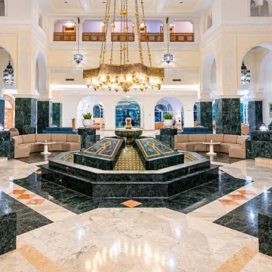 Grand hall luxueux avec fontaine centrale et lustres orientaux à l'hôtel Djerba Golf Resort & Spa.
