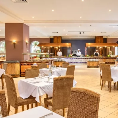 Salle de restauration élégante et buffet avec chefs cuisiniers en action pour des vacances gourmandes en Tunisie.