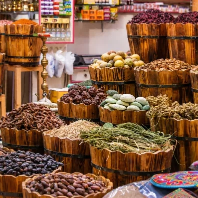 Épices colorées et produits locaux exposés dans des paniers en bois au souk de Louxor, Égypte.