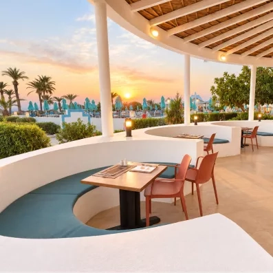 Restaurant avec des banquettes et des chaises, avec une belle vue sur le complexe du Helya Beach à Monastir en Tunisie