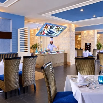 Buffet de poissons frais au restaurant Jaz Aquamarine Hurghada, chef cuisinier et tables dressées, séjour luxe Égypte.
