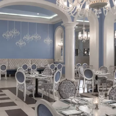 Salle de restaurant lumineuse Jaz Aquamarine Hurghada, colonnes blanches, décoration bleue, vacances de luxe Égypte.