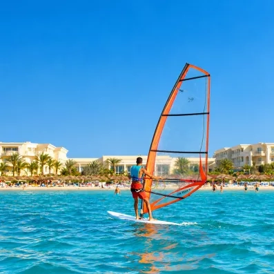 Planche à voile sur les eaux turquoise de la Méditerranée face au complexe Royal Thalassa Monastir.