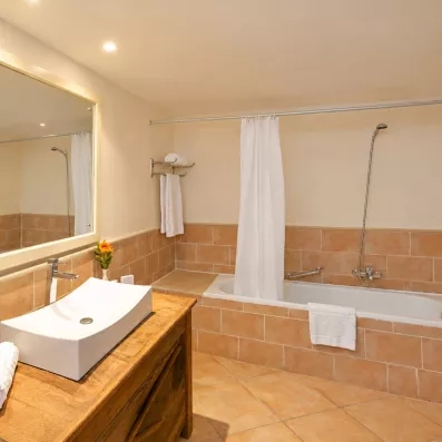 Salle de bain moderne et lumineuse avec baignoire, vasque design et carrelage typique de l'hôtel Safira Palms.