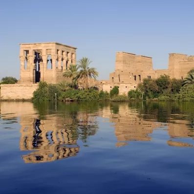 Temple de Philae se reflétant sur les eaux du Nil, monument historique incontournable, voyage en Égypte.