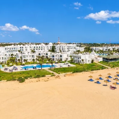 Vue aérienne du complexe hôtelier Helios Beach à Djerba, entre jardins verdoyants et plage de sable fin.