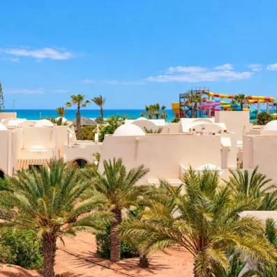 Architecture mauresque des bungalows blancs face à la mer turquoise sous le soleil de Djerba, Tunisie.