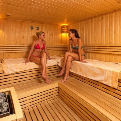 2 femmes profitant dans la cabine sauna avec deux serviettes 